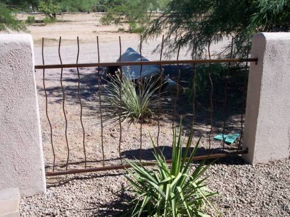Rust iron fence with wavy rebar with masonry posts IF303 Rebar - installed in Tucson